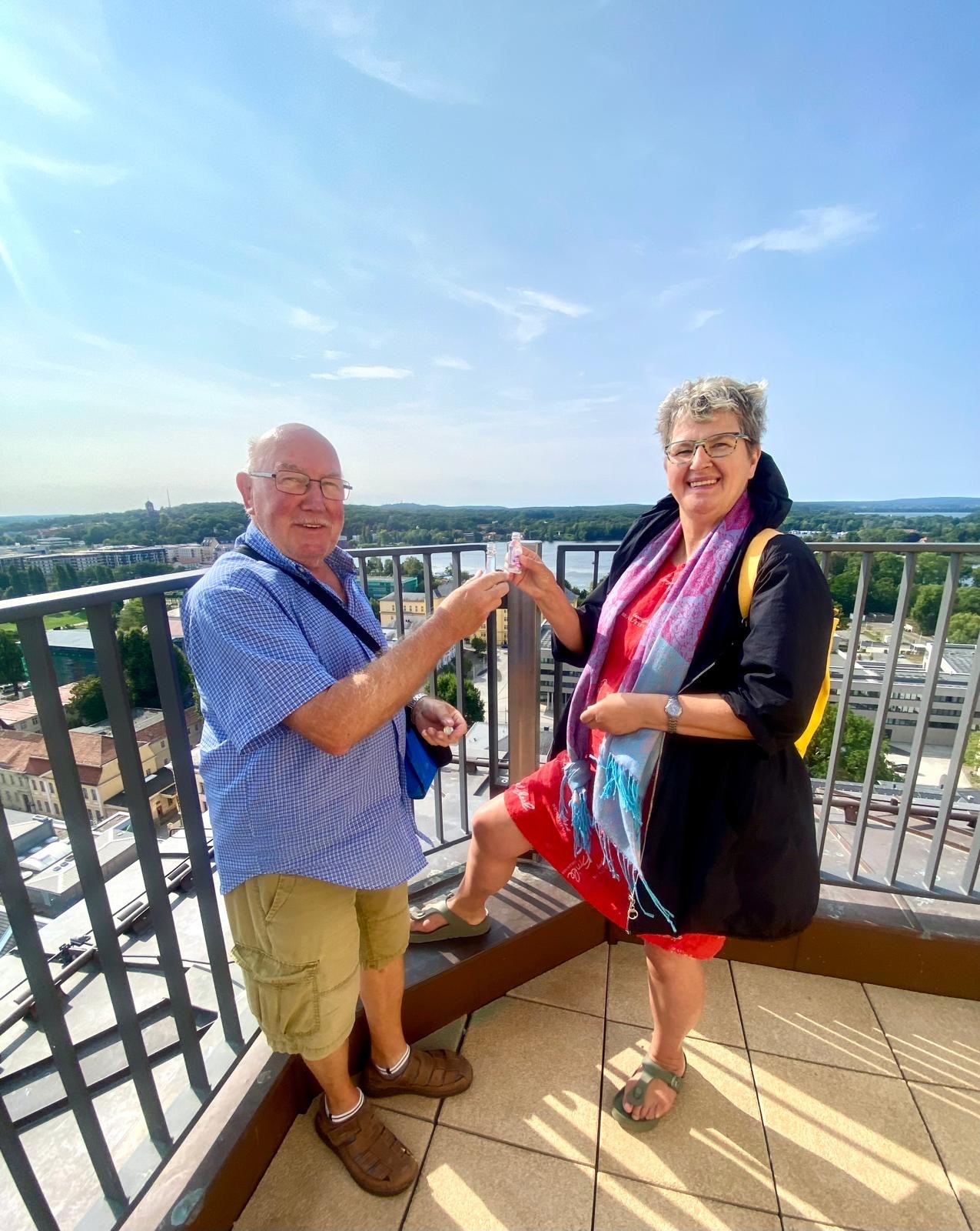 Ein Ehepaar stößt am ersten Öffnungstag der Garnisonkirche auf der Aussichtsplattform "Potsdam Panorama" an.